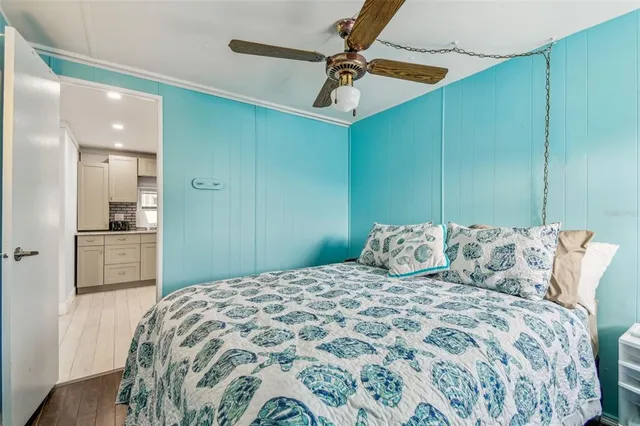 a bedroom with a large bed and a chandelier fan