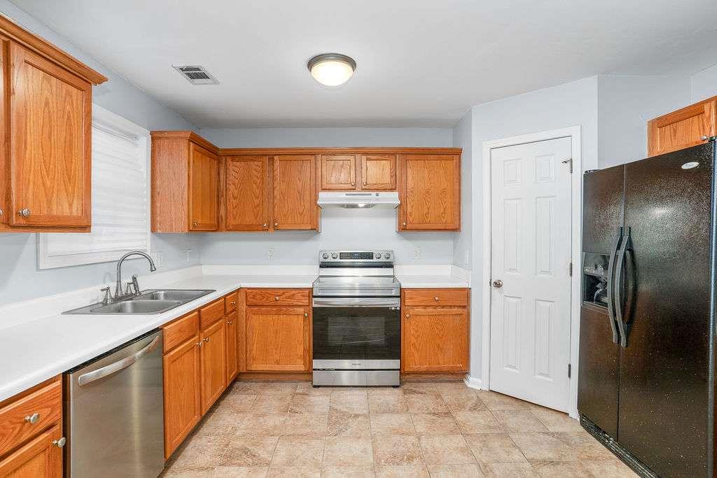 1461 Enchanted Forest Drive Conley, GA 30288 - Photo 12 of 47 a kitchen with stainless steel appliances granite countertop a sink stove and refrigerator
