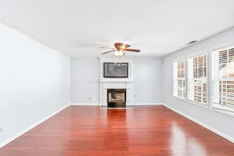 a view of empty room with wooden floor and fireplace