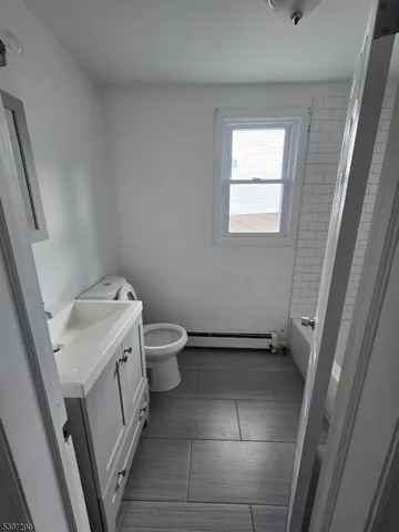 a bathroom with a sink a toilet and a window