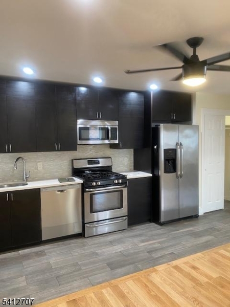 a kitchen with stainless steel appliances kitchen island granite countertop a refrigerator and a sink