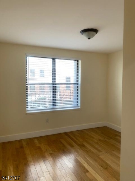 73 Ferry Street Newark, NJ 07105 - Photo 4 of 6 a view of an empty room with wooden floor and a window