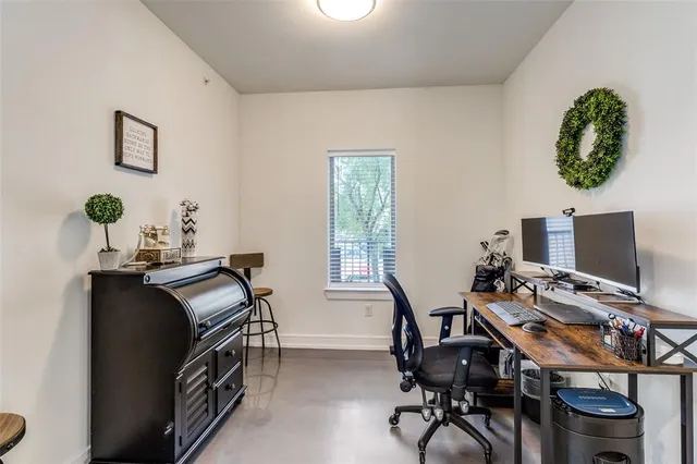 a view of a workspace with furniture and a window