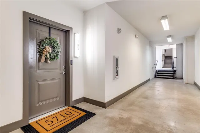 a view of a hallway to a livingroom with furniture