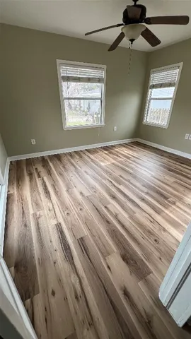 a view of a hallway with wooden floor and staircase
