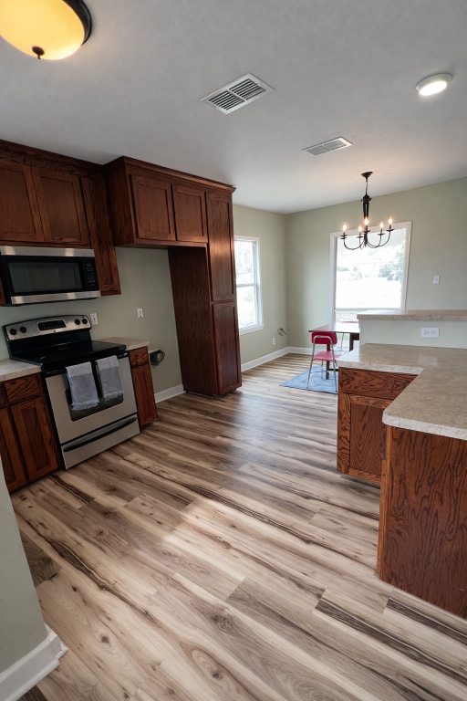 305 West Davilla Street Granger, TX 76530 - Photo 5 of 20 a kitchen view with wooden floor and electronic appliances