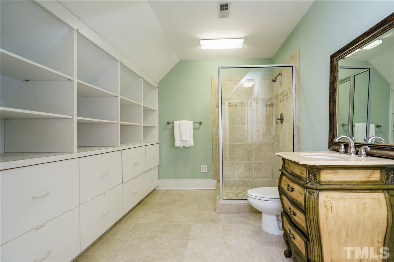 7628 Rainwater Road Raleigh, NC 27615 - Photo 20 of 25 a bathroom with a granite countertop sink a toilet a mirror and shower
