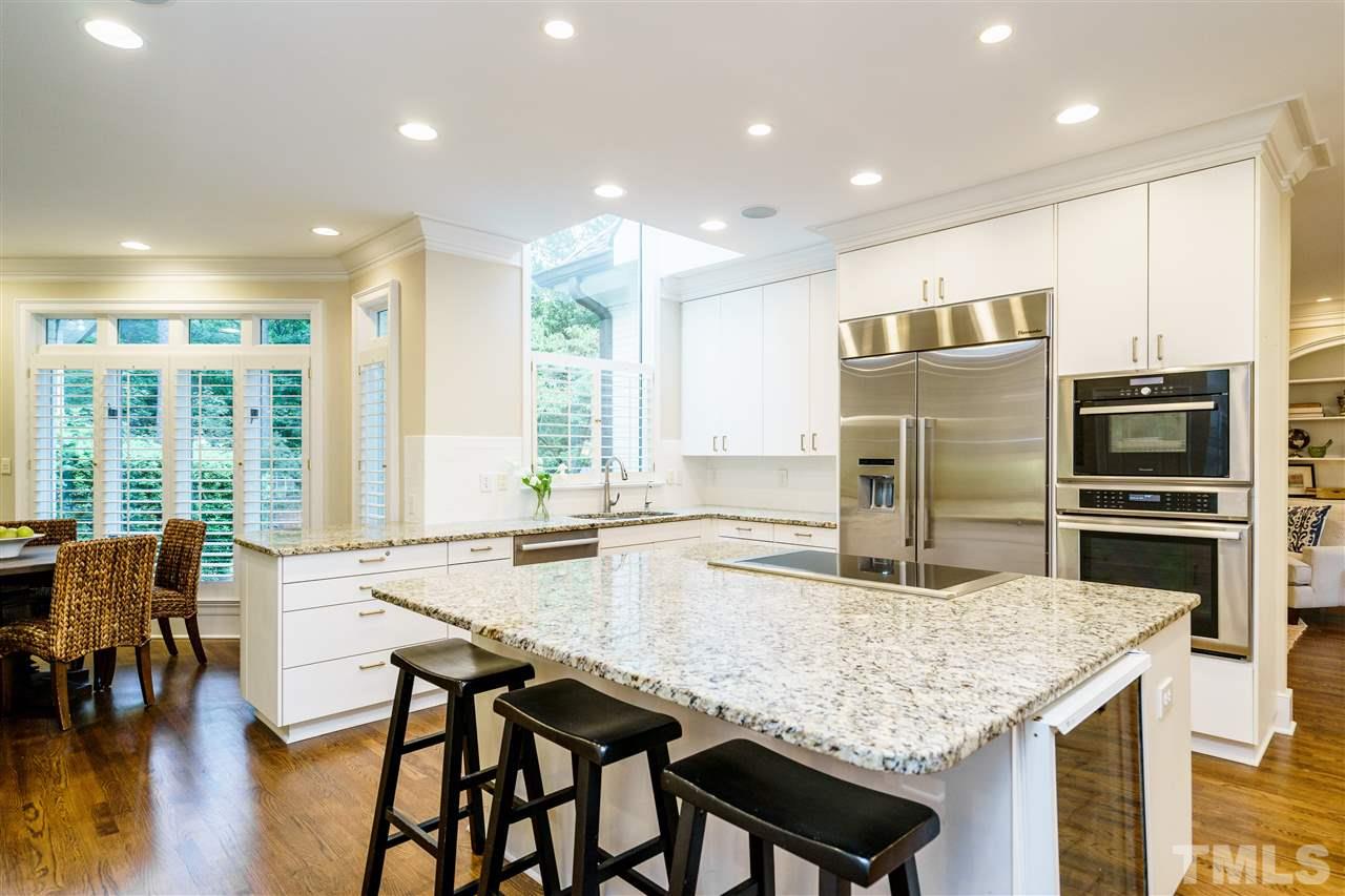 7628 Rainwater Road Raleigh, NC 27615 - Photo 7 of 25 a kitchen with granite countertop a table and chairs in it
