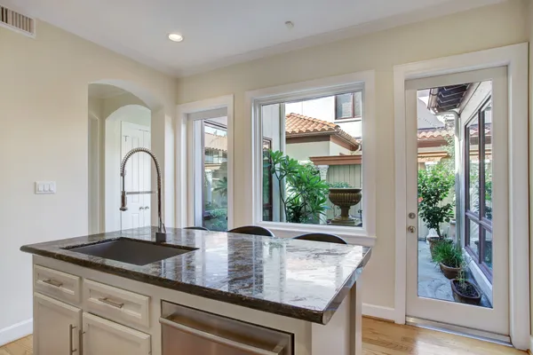 a kitchen with granite countertop a sink and refrigerator