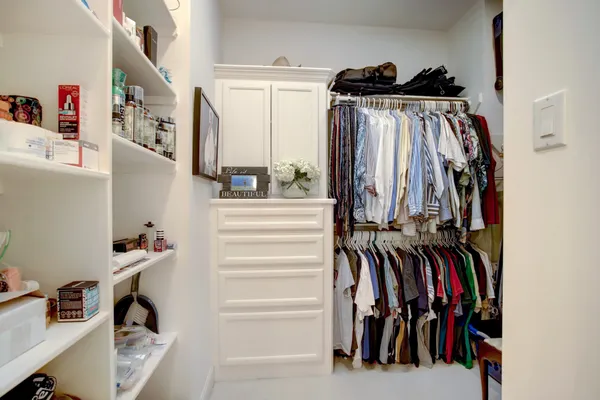 a view of walk in closet with clothes and shoes