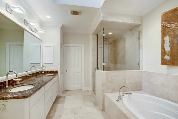a bathroom with a granite countertop tub sink and mirror