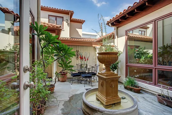 a view of a house with sitting area and potted plants