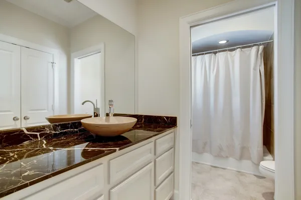 a bathroom with a granite countertop sink and a mirror