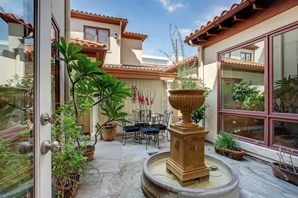 a view of a house with sitting area and potted plants
