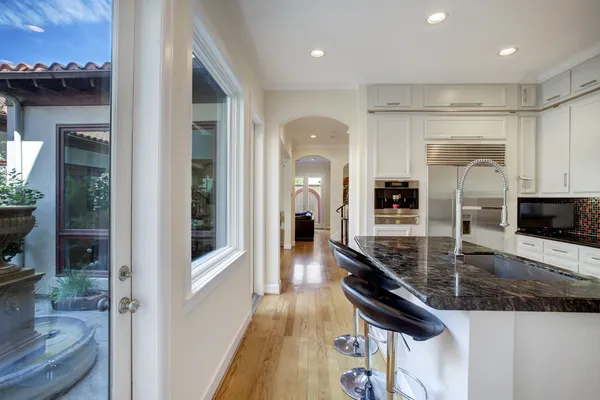 a kitchen with stainless steel appliances granite countertop a sink refrigerator and cabinets