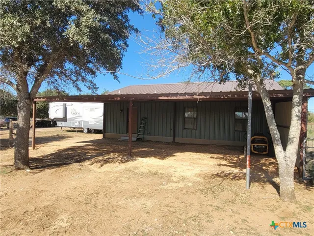 a backyard of a house with table and chairs