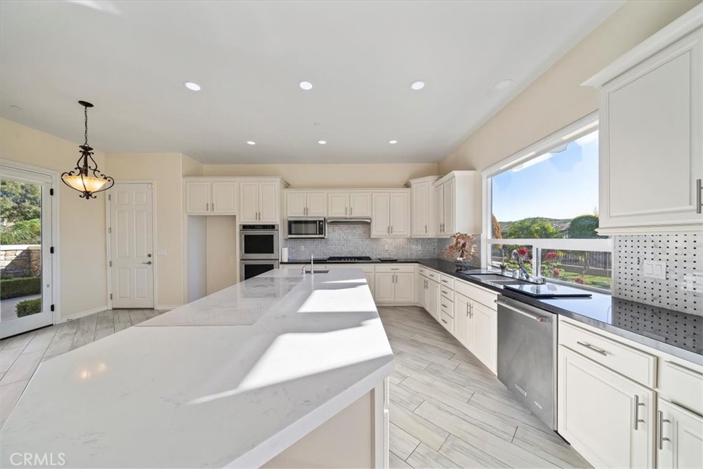 3094 Crystal Ridge Lane Colton, CA 92324 - Photo 28 of 68 a large kitchen with kitchen island a large counter top a sink a window and stainless steel appliances