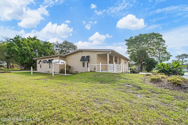 a backyard of a house with plants and large trees
