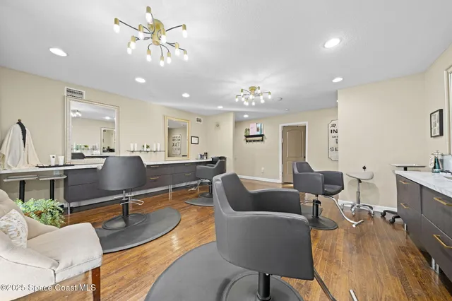 a living room with furniture kitchen view and a chandelier