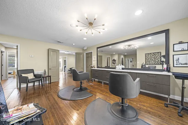 a living room with furniture a wooden floor and kitchen view