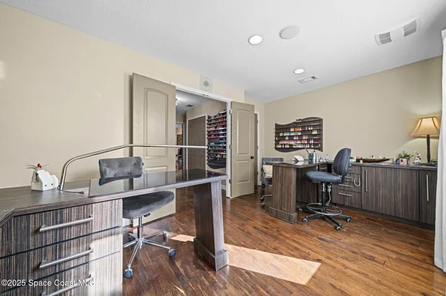 a view of a workspace with furniture and a window