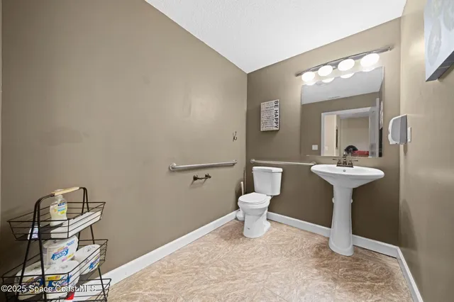 a bathroom with a sink a toilet and mirror