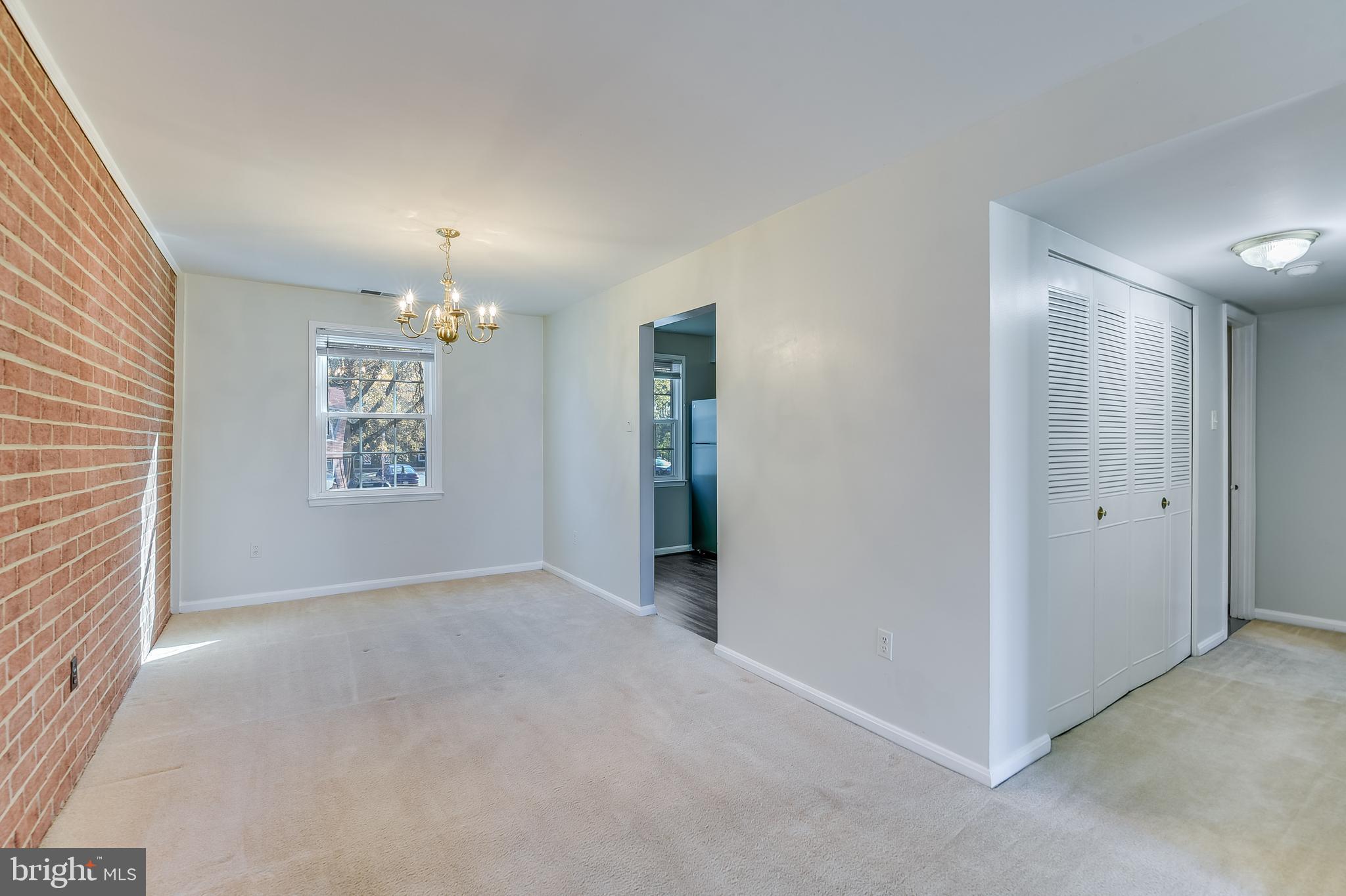 762 Quince Orchard Boulevard, Unit 101 Gaithersburg, MD 20878 - Photo 11 of 21 an empty room with chandelier fan and windows