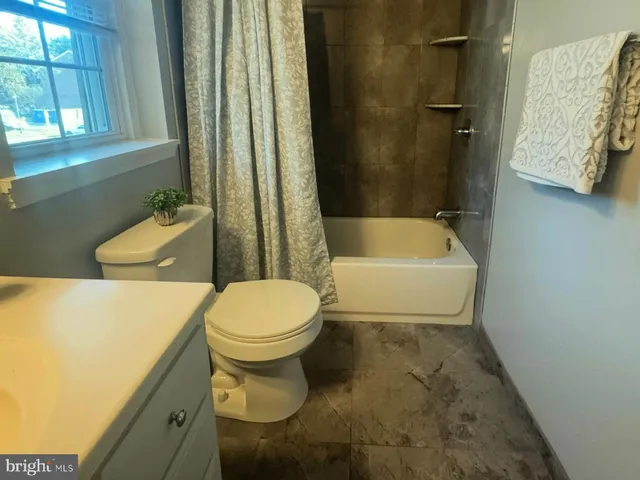 a white toilet sitting next to a bathroom sink and tub
