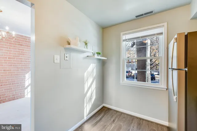 a view of a kitchen with wooden floor and a window