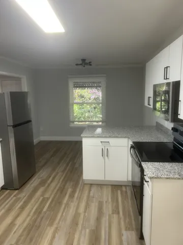 a kitchen with granite countertop a refrigerator and a sink