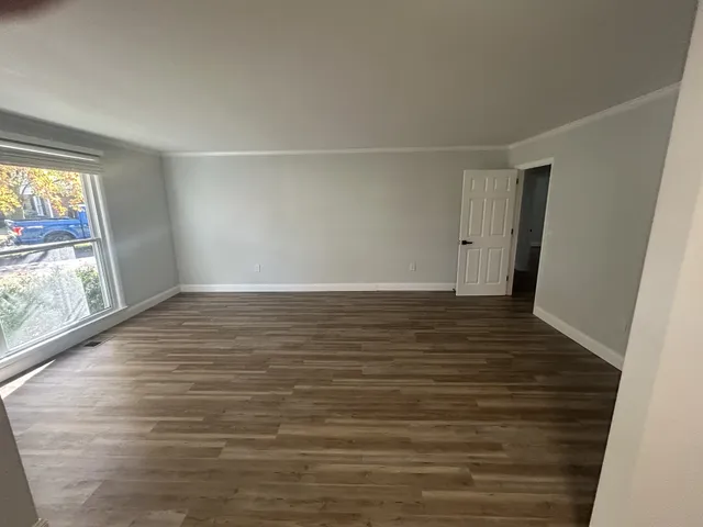 a view of room with window and wooden floor