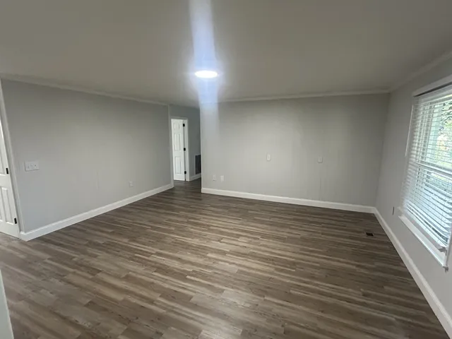 wooden floor in an empty room with a window