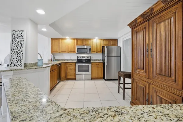 a kitchen with stainless steel appliances granite countertop a sink a stove top oven a granite counter space and cabinets