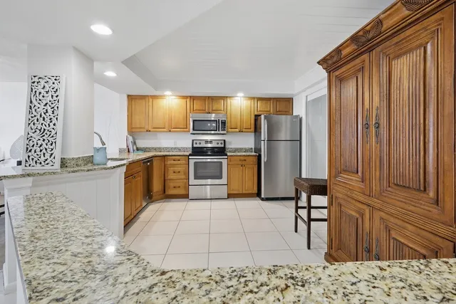 a kitchen with stainless steel appliances granite countertop a sink a stove top oven a granite counter space and cabinets