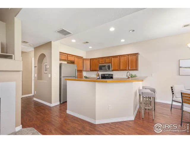 a view of kitchen with stainless steel appliances granite countertop a refrigerator a stove top oven and a sink