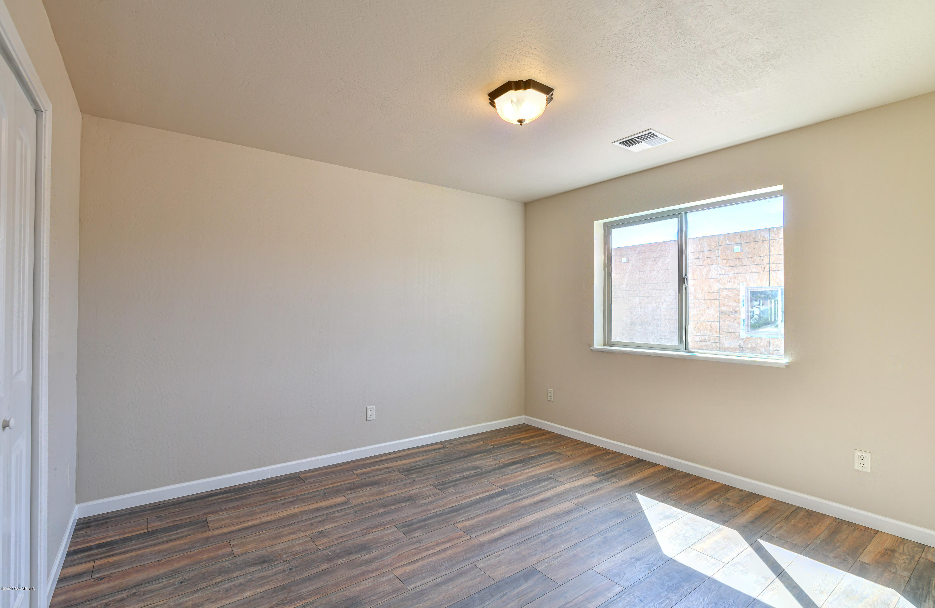 4645 East Goldmine Road Rimrock, AZ 86335 - Photo 16 of 24 an empty room with wooden floor and windows