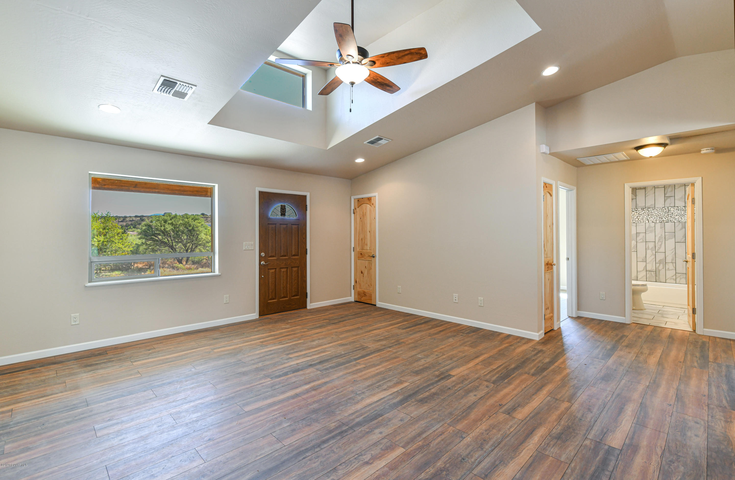 4645 East Goldmine Road Rimrock, AZ 86335 - Photo 8 of 24 an empty room with wooden floor and a ceiling fan