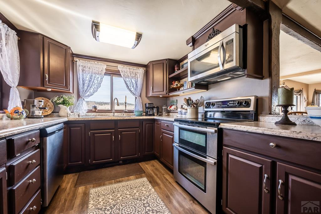 8419 3 R Road Beulah, CO 81023 - Photo 12 of 46 a kitchen with stainless steel appliances granite countertop wooden cabinets a stove top oven a sink and dishwasher