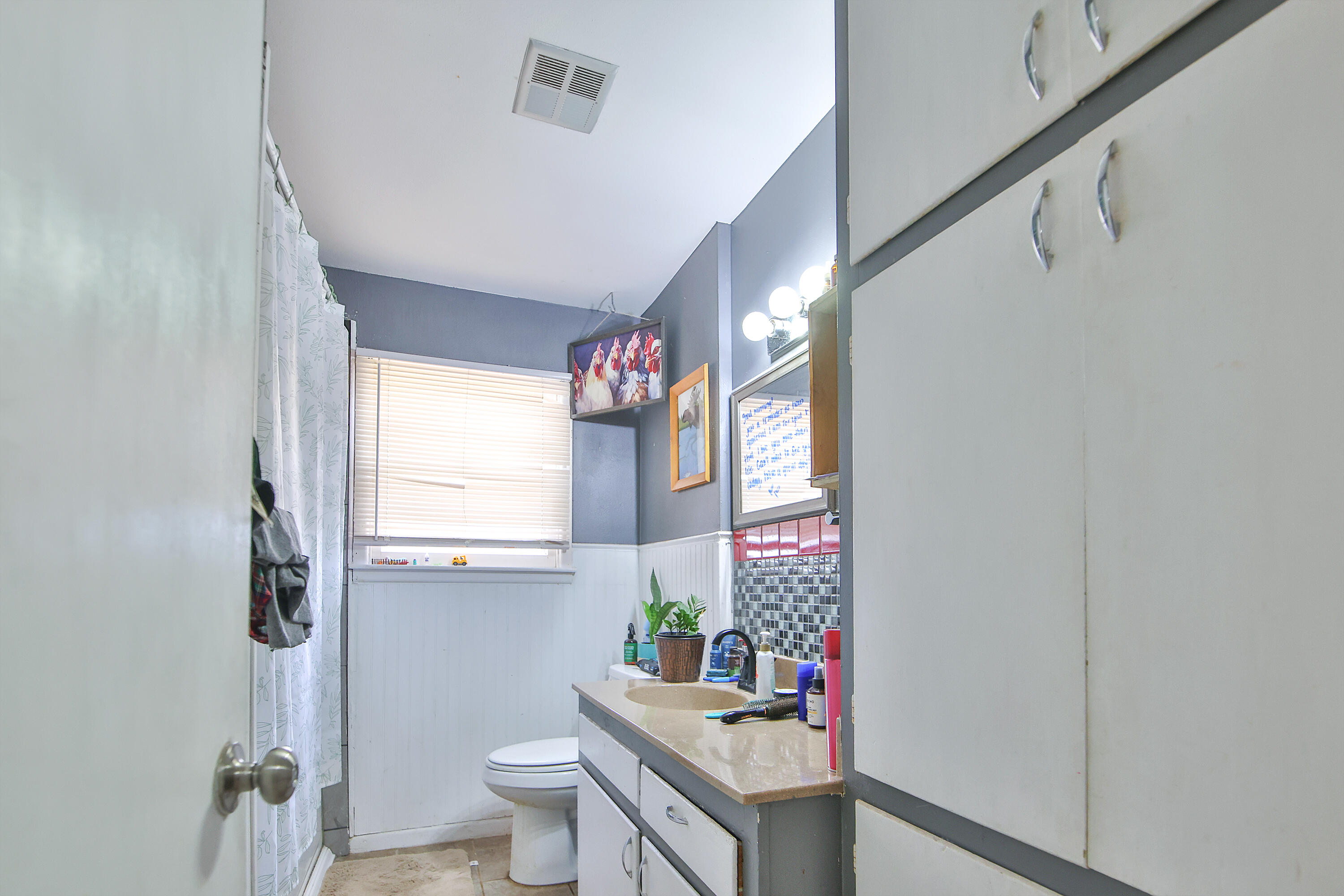 4518 49th Street Lubbock, TX 79414 - Photo 13 of 32 a bathroom with a sink toilet and a mirror