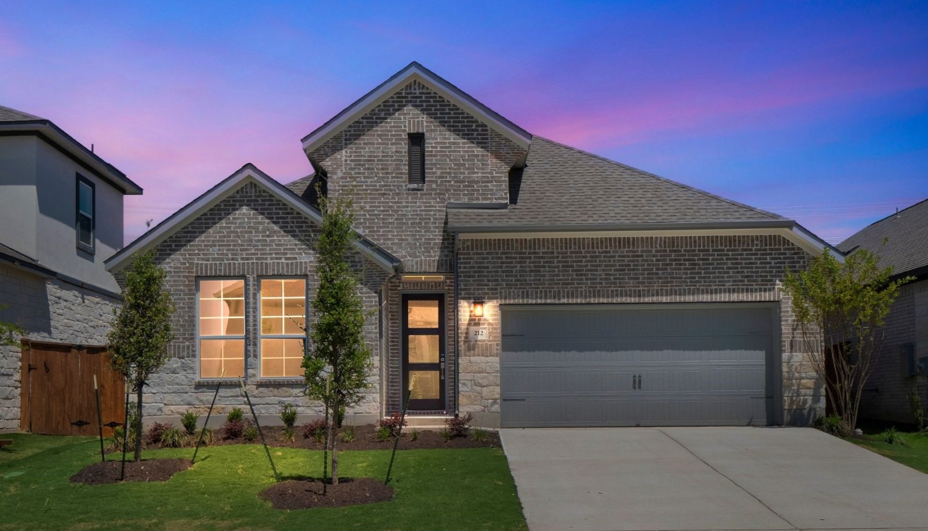 212 Millbend Road Georgetown, TX 78633 - Photo 1 of 1 View of front of house with a shingled roof, an attached garage, brick siding, a front lawn, and driveway