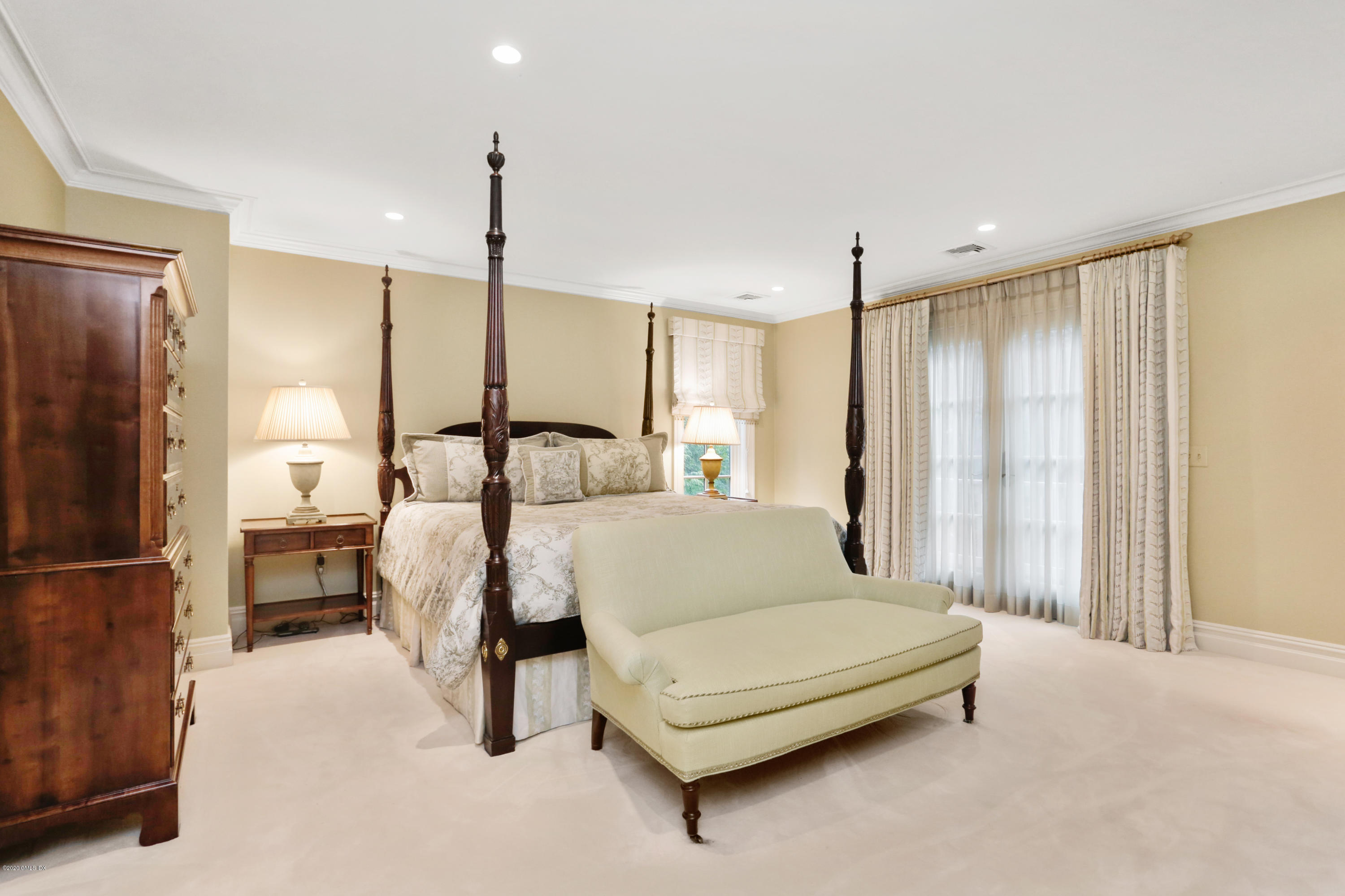 65 Ridgeview Avenue Greenwich, CT 06830 - Photo 19 of 50 a spacious bedroom with a bed and a chandelier