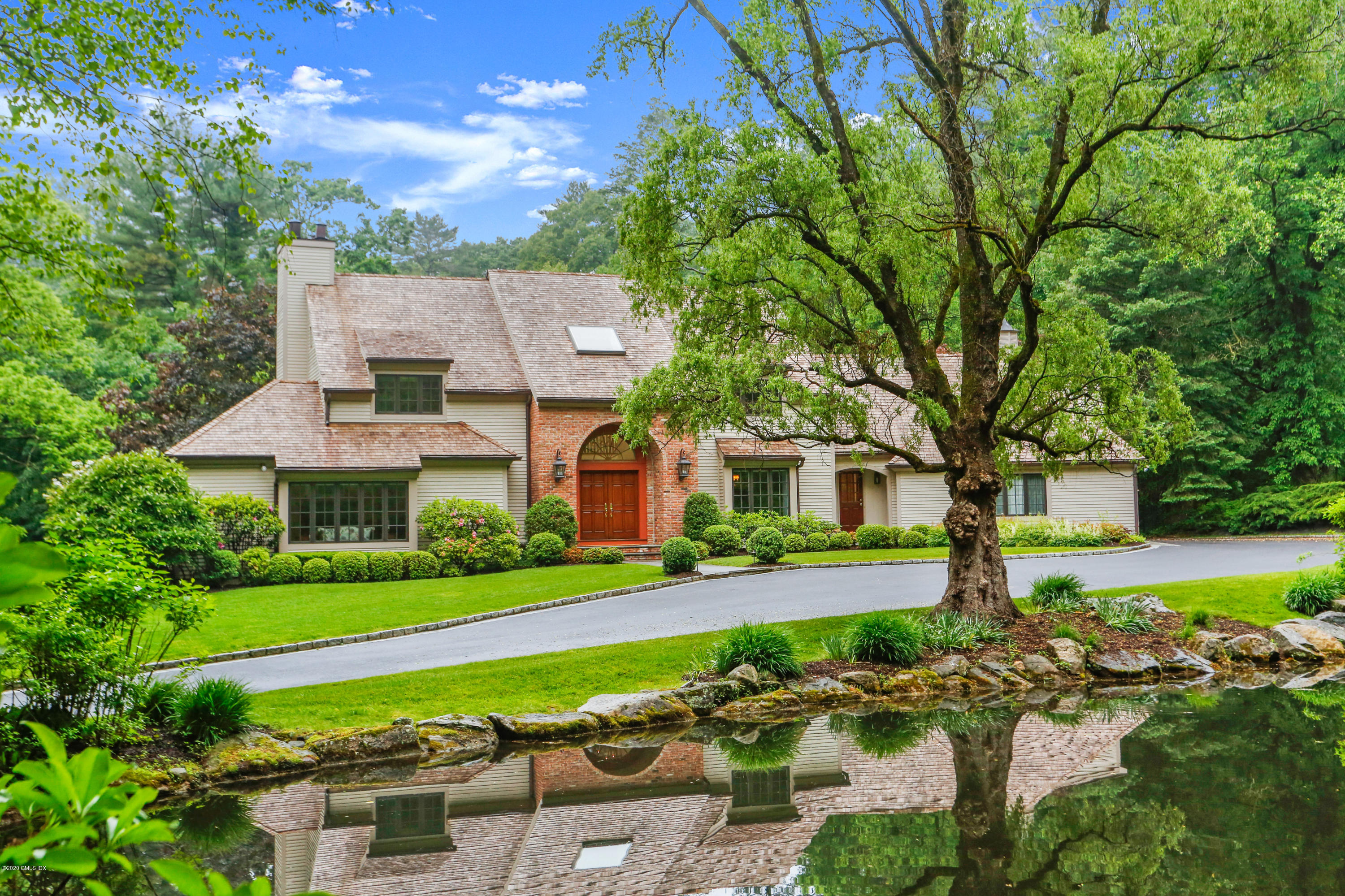 65 Ridgeview Avenue Greenwich, CT 06830 - Photo 42 of 50 a front view of a house with a yard table and chairs