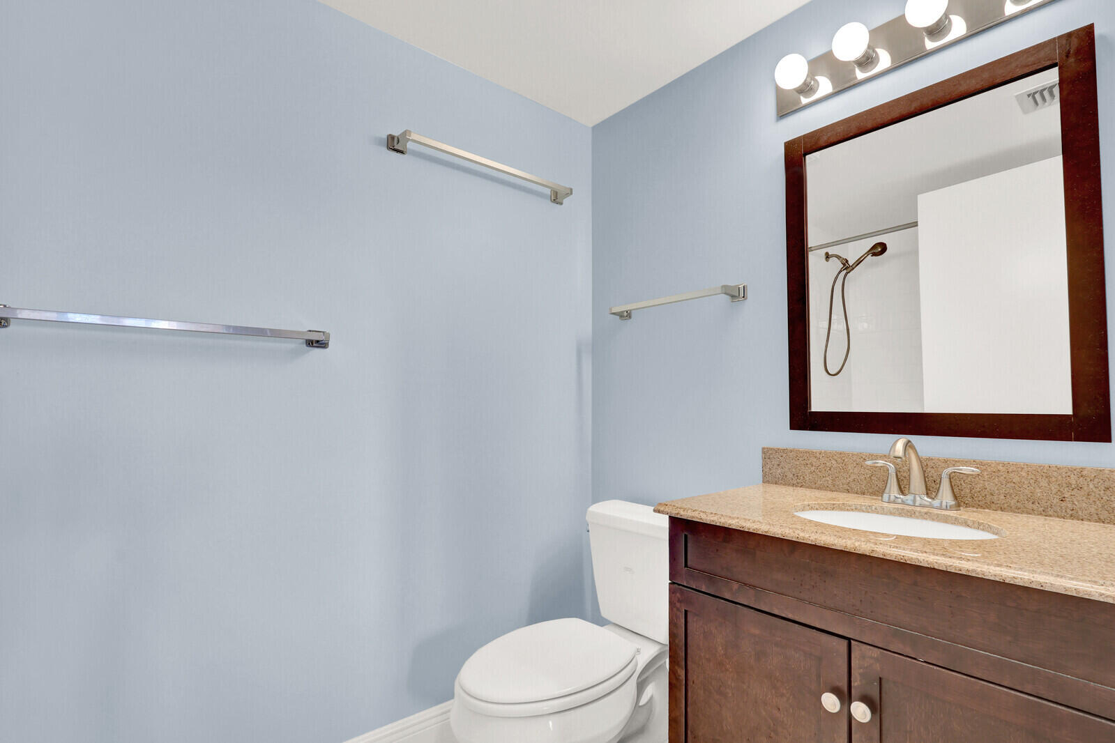 353 Highway 1, Unit D105 Jupiter, FL 33477 - Photo 34 of 56 a bathroom with a toilet a sink a vanity and mirror