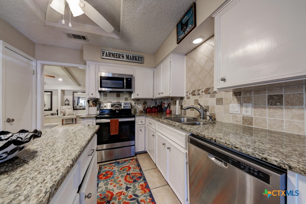 1229 Rapids Road New Braunfels, TX 78130 - Photo 10 of 27 a large kitchen with granite countertop stainless steel appliances and a counter space