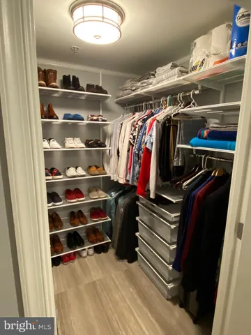 a view of walk in closet with clothes and shoes