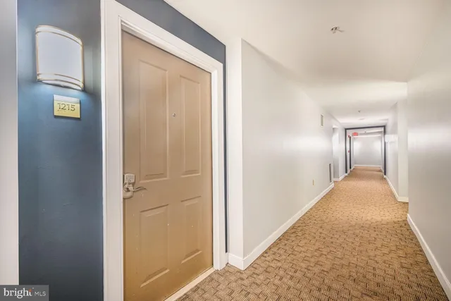 a picture of a room with a white bed and a painting on the wall