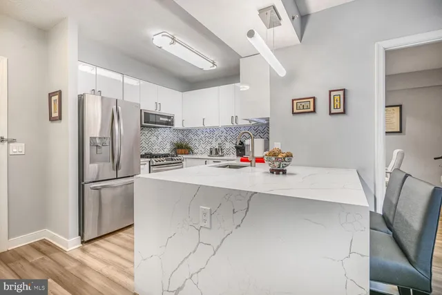 a kitchen with stainless steel appliances a refrigerator sink and microwave