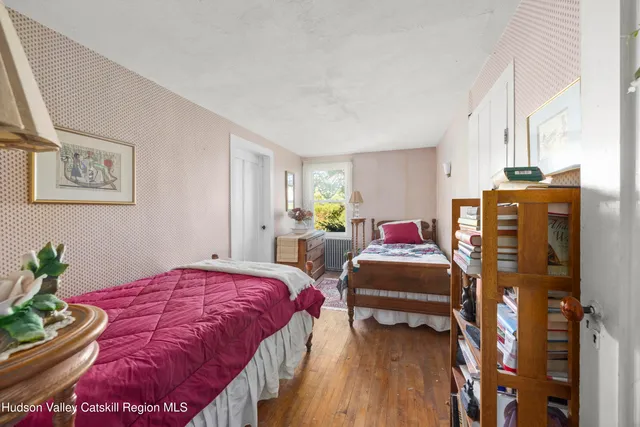 a bedroom with a bed and a wooden floor