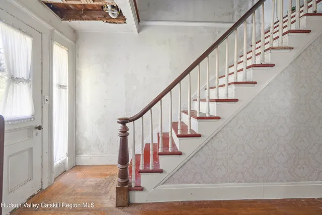 a view of entryway with wooden floor and stairs
