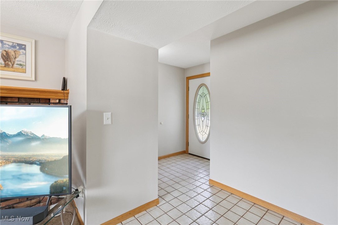 5877 Pearl Road Cleveland, OH 44130 - Photo 6 of 42 Foyer featuring light tile patterned floors and a textured ceiling